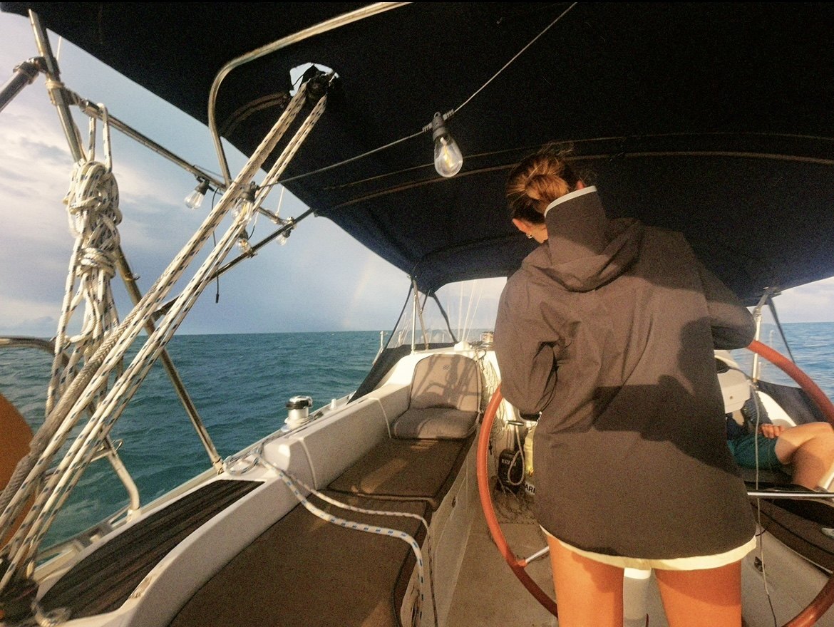 A gal at the helm in foul weather gear offshore