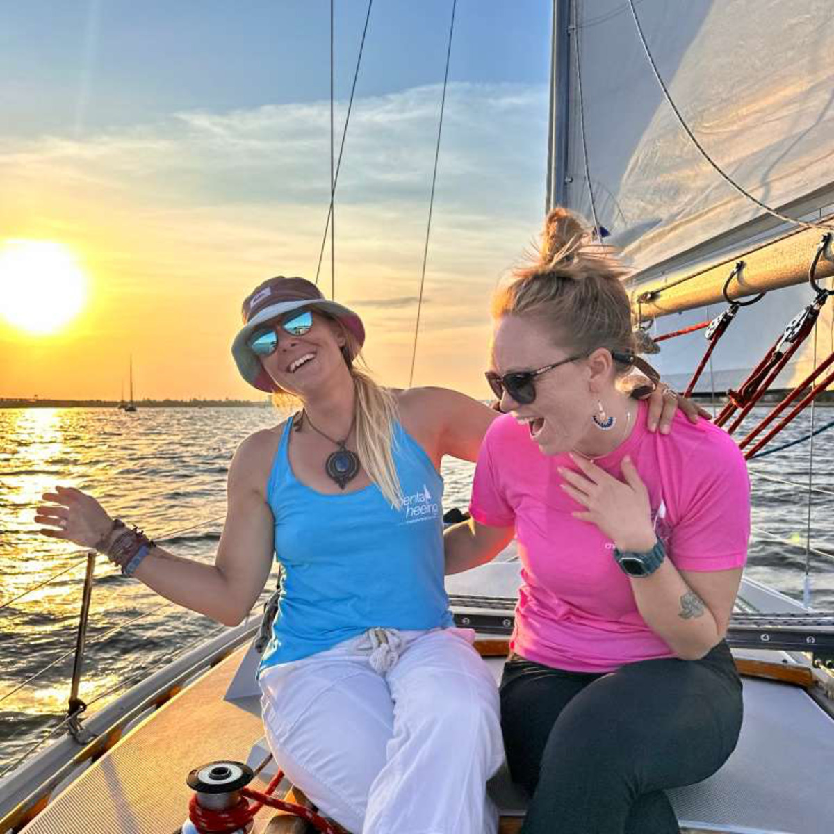 Two Maritime Gals laughing in the cockpit at sunset